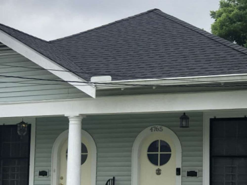 A residential house with a dark roof and green siding located at 4765.